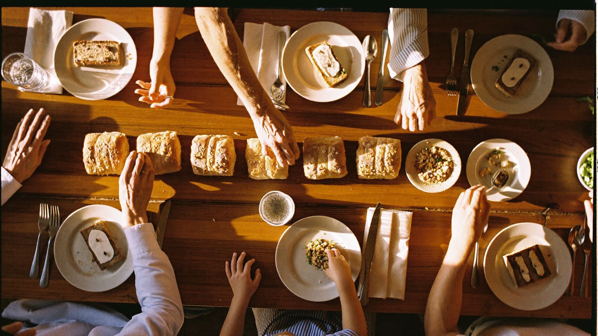 Three generations of hands sharing one family table